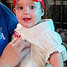 Tatum joined the competition — help win amazing prizes! toddler, child, red_bow, headband, red_pants, white_hearts, adult_hand, blue_shirt, indoor, curtains, patterned_rug, happy, smiling, person, baby_clothing, cute, holding, portrait, family, cozy