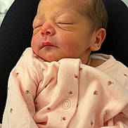 Milah is registered to the contest to win money with this photo: newborn, baby, sleeping, infant, pink_clothing, floral_pattern, soft_fabric, portrait, close_up, peaceful, resting, cute, child, human, skin, head, face, small, indoors, cozy