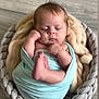 baby, sleeping, blanket, basket, wood_floor, cozy, wrapped, infant, soft, cute, child, peaceful, indoor, newborn, plush, floor, portrait, resting, hands, feet