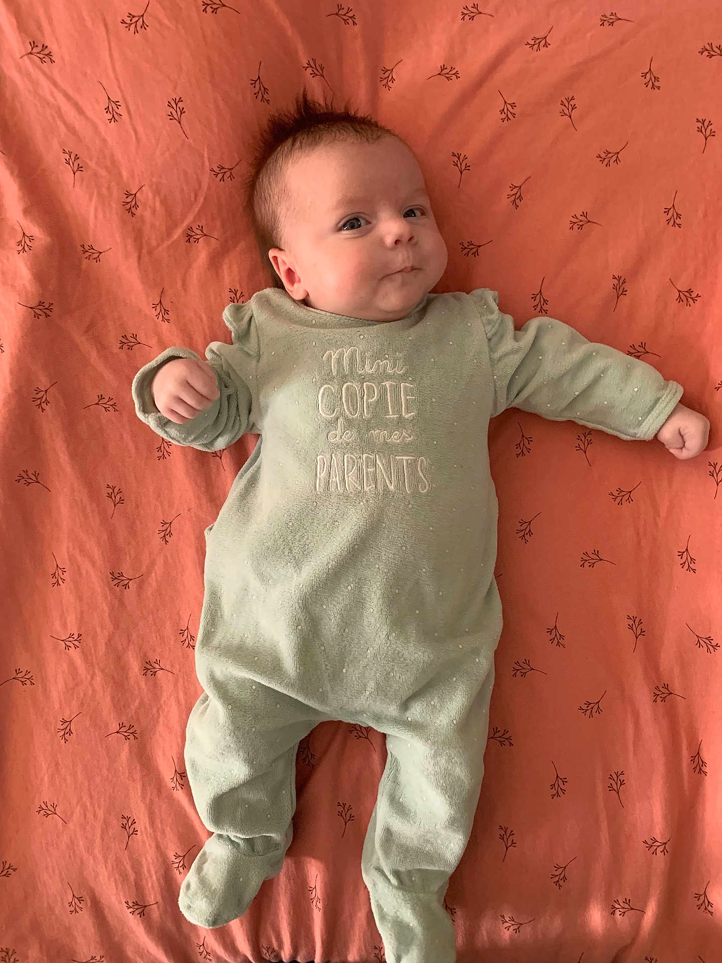 Carolina a rejoint le concours — aidez-le/la à gagner de superbes lots ! baby, infant, onesie, bedspread, fabric, pattern, lying_down, smile, face, hair, mint_green, coral, text_on_clothing, cute, child, person, sleepwear, soft_texture, indoors, portrait