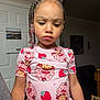 child, girl, braids, beads, pink_shirt, strawberry_pattern, indoor, portrait, expression, person, clothing, calendar, door, furniture, hair, earrings, lighting, standing, face, cute