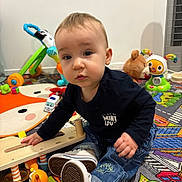 Ugo participe au concours pour gagner de l'argent avec cette photo : baby, candid, carpet, child, clothing, colorful, curious, cute, denim_pants, floor, indoor, person, plastic_toy, play_mat, playtime, sneakers, stuffed_animal, toddler, toy, young_child
