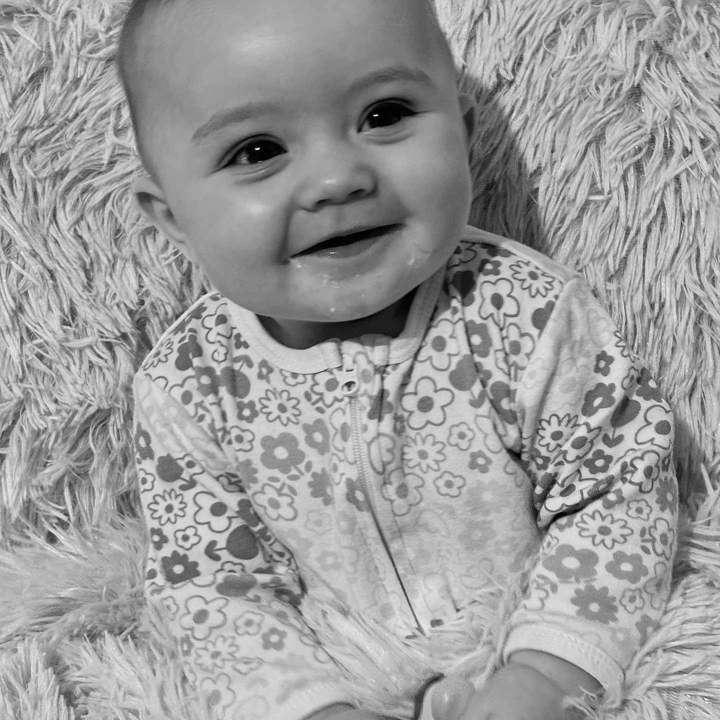 Raven joined the competition — help win amazing prizes! baby, black_and_white, blanket, child, closeup, cozy, cute, face, floral_pattern, hands, happy, indoors, infant, onesie, portrait, sitting, smiling, soft_texture, warm, young