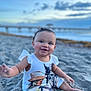 baby, child, beach, sand, smiling, happy, outdoor, sunset, pier, water, sky, clouds, infant, sitting, clothing, portrait, cute, playful, nature, footwear