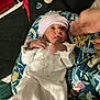 Jakiylah is registered to the contest to win money with this photo: baby, bed, blanket, child, comfort, cushion, cute, face, floral_pattern, hand, hat, indoor, infant, newborn, person, plush_toy, resting, sleepwear, soft_toy, white_clothing