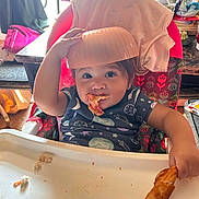Amaiahkali is registered to the contest to win money with this photo: toddler, child, high_chair, pizza, food, bowl, eating, smiling, indoor, kitchen, clothing, face, hand, tray, snack, cheese, table, seat, person, playful