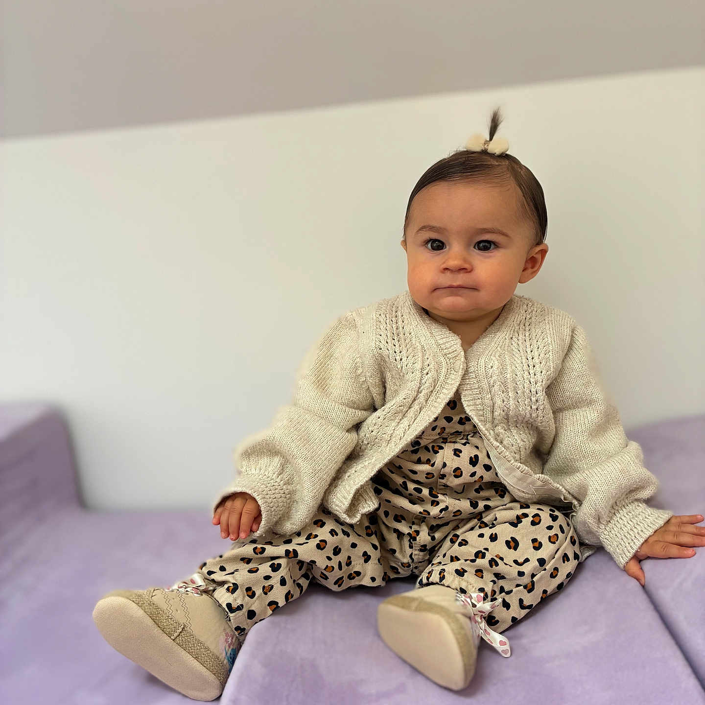 Rose Percebois a rejoint le concours — aidez-le/la à gagner de superbes lots ! toddler, child, baby, sitting, couch, purple_couch, knitted_sweater, leopard_print, footwear, indoor, cute, portrait, person, small_pony_tail, clothing, furniture, expression, home, soft_lighting, casual