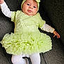 baby, infant, tutu_dress, headband, green_dress, white_tights, couch, fabric, portrait, cute, child, smiling, sitting, indoors, fashion, baby_clothes, soft_texture, comfortable, young_child, cozy