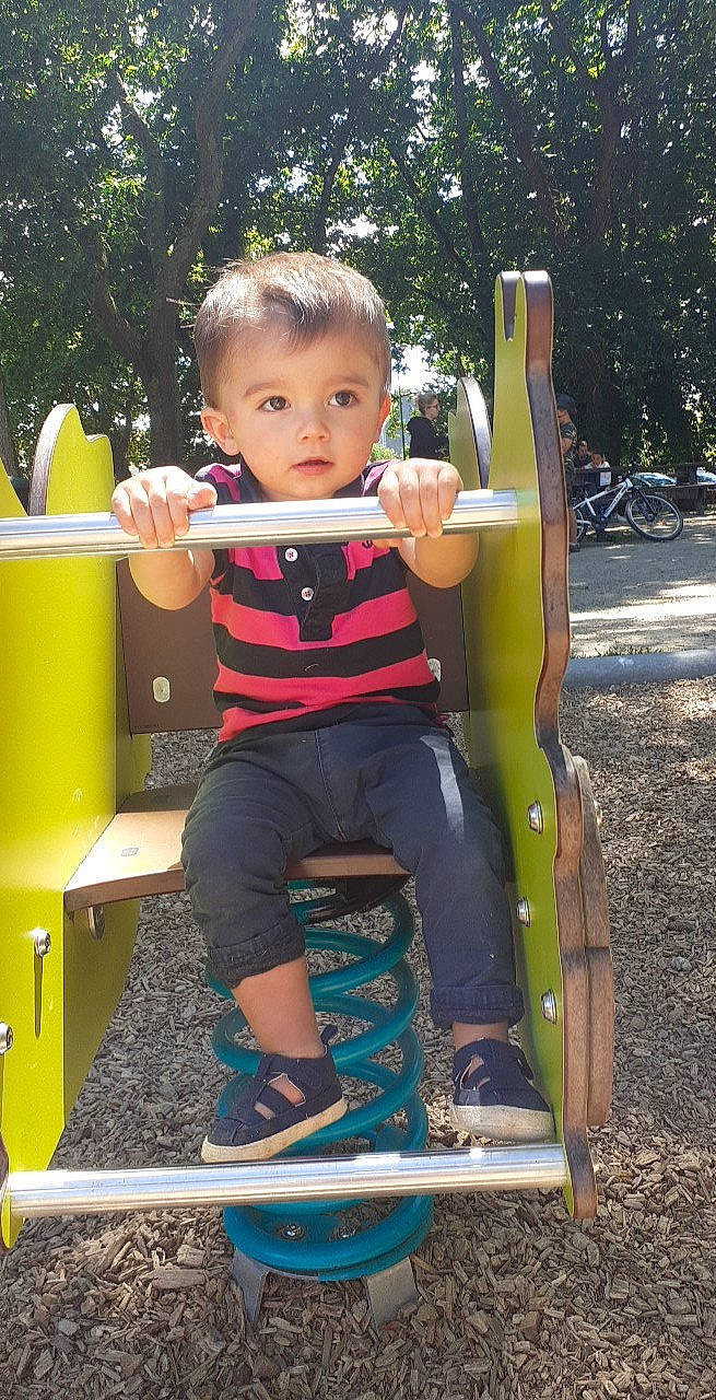 Lény a rejoint le concours — aidez-le/la à gagner de superbes lots ! baby, baby_toddler_clothing, child, chute, city, fun, grass, happy, human_settlement, leisure, outdoor_furniture, outdoor_play_equipment, person, play, playground, recreation, shorts, sitting, summer, toddler