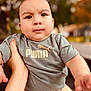 baby, child, puma, tshirt, pants, hand, outdoor, portrait, face, person, clothing, expression, serious, skin, short_sleeve, holding, autumn, blurred_background, nature, daylight