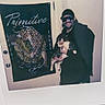 Cheeto is registered to the contest to win money with this photo: man, cat, door, tapestry, leopard, artwork, spiderman, sunglasses, cap, indoor, wall, smile, person, animal, pet, holding, clothing, portrait, decor, casual