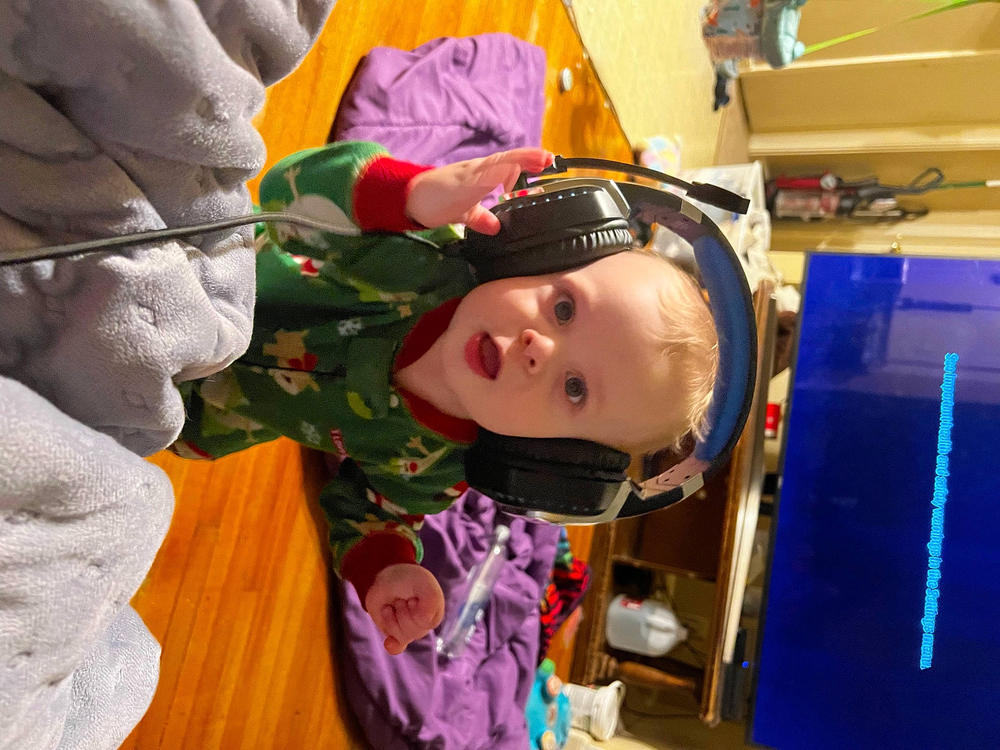 Dean is registered to the contest to win money with this photo: audio_equipment, baby, cheek, child, comfort, computer_monitor, event, eyewear, fun, gadget, happy, mouth, person, personal_protective_equipment, room, toddler