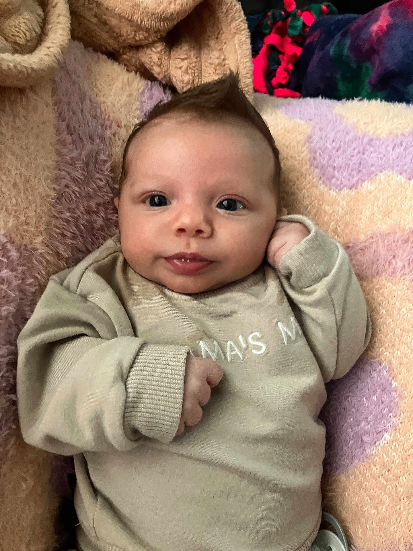 Aurora joined the competition — help win amazing prizes! baby, infant, child, face, smile, hair, mohawk, sweater, clothing, blanket, soft_texture, cozy, indoors, cute, portrait, person, lying_down, skin, head, expression