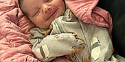 Aurora is registered to the contest to win money with this photo: baby, newborn, smiling, blanket, pink, onesie, sleeping, face, infant, cute, cozy, child, soft, fabric, pattern, resting, comfort, portrait, indoor, clothing