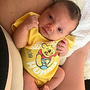 Aurora is registered to the contest to win money with this photo: baby, infant, yellow_onesie, winnie_the_pooh, clothing, person, skin, blanket, soft, cute, newborn, legs, arms, hand, foot, lying_down, closeup, indoors, comfort, rest