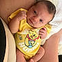 baby, infant, yellow_onesie, winnie_the_pooh, clothing, person, skin, blanket, soft, cute, newborn, legs, arms, hand, foot, lying_down, closeup, indoors, comfort, rest