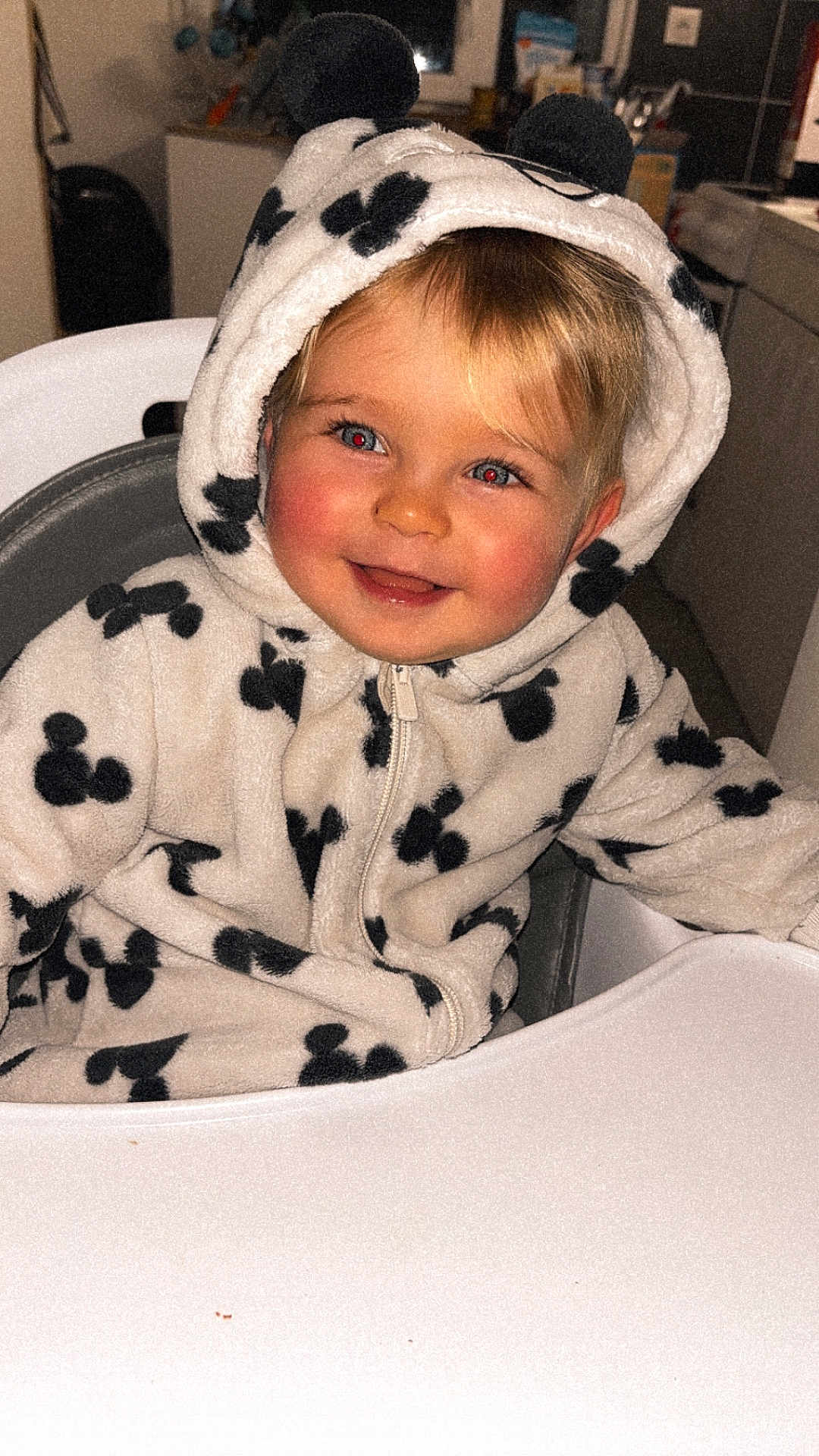 Isaac a rejoint le concours — aidez-le/la à gagner de superbes lots ! child, toddler, hoodie, mickey_mouse, black_and_white, high_chair, smiling, indoors, face, red_eye, happy, blond_hair, zipper, cozy, cute, person, clothing, seated, baby, portrait