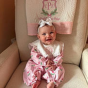 Charlotte joined the competition — help win amazing prizes! baby, infant, headband, bow, pink_outfit, tulip_pattern, quilted_towel, armchair, nursery_chair, smile, rosy_cheeks, sitting, bare_feet, hands_clasped, portrait, soft_texture, embroidered_monogram, pink_color_palette, cozy, adorable