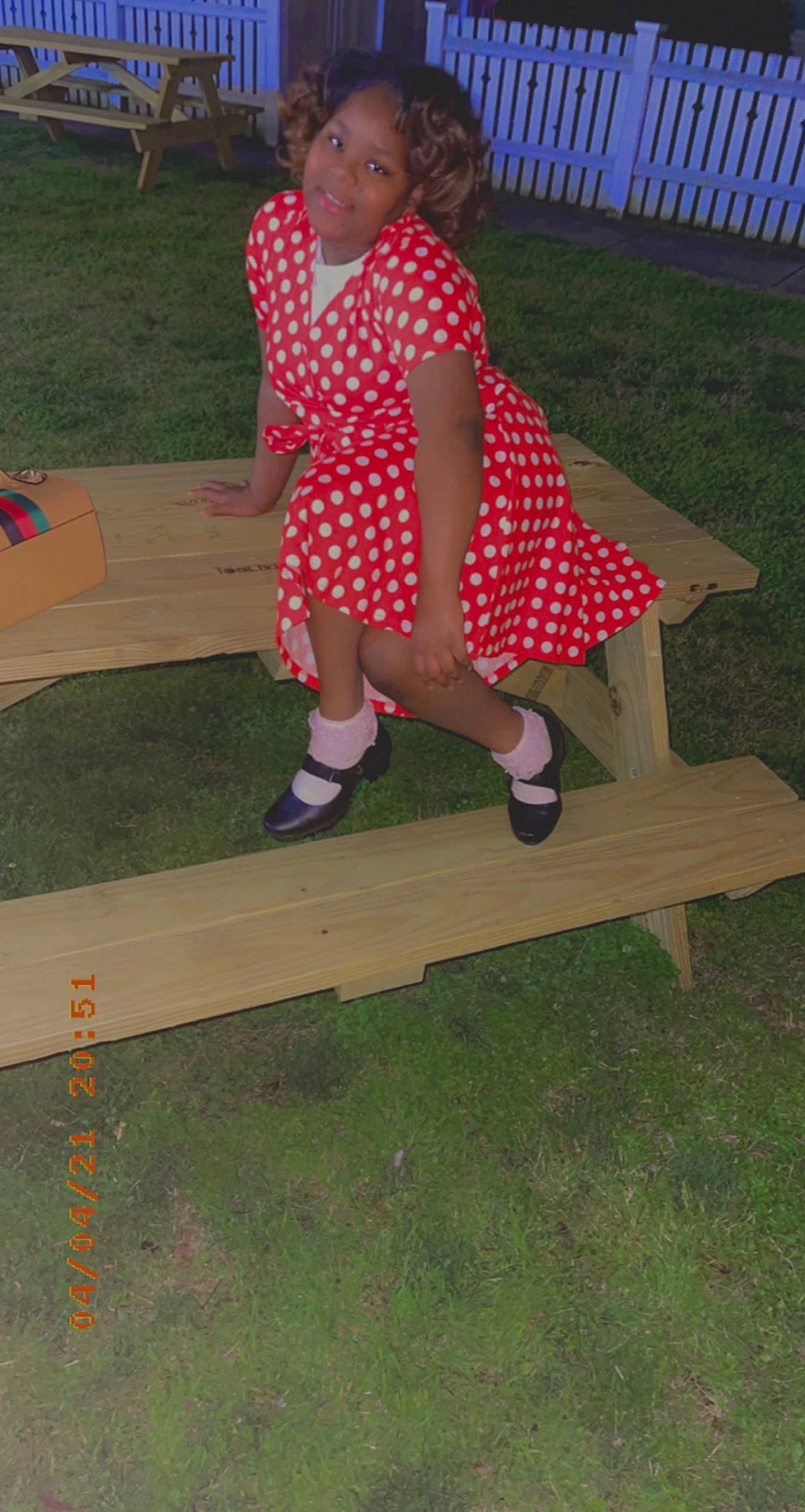 Leah is registered to the contest to win money with this photo: baby_toddler_clothing, calf, dress, foot, fun, grass, human_leg, joy, knee, leisure, magenta, outdoor_bench, outdoor_furniture, pattern, person, pink, recreation, sleeve, thigh, tints_and_shades