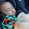 baby, sleeping, car_seat, toy, blanket, hand, infant, child, colorful, cozy, peaceful, closeup, indoor, soft_lighting, portrait, cute, rest, comfort, seatbelt, fabric