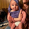 Kylan joined the competition — help win amazing prizes! baby, child, adult, indoor, wood_panel_wall, purple_clothing, diaper, holding, smile, person, face, hand, jeans, cozy, casual, candid, expression, skin, wide_eyes, warm_lighting