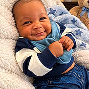 Zahli-Emyr is registered to the contest to win money with this photo: baby, infant, child, smiling, portrait, indoor, blanket, bib, teddy_bear, toy, sitting, lying_down, clothing, blue, happy, face, hands, nursery, cozy, photography