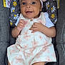 baby, car_seat, child, clothing, cute, dress, eyes, face, floral_pattern, foot, hand, happy, headband, indoors, infant, mouth, person, seatbelt, skin, smiling