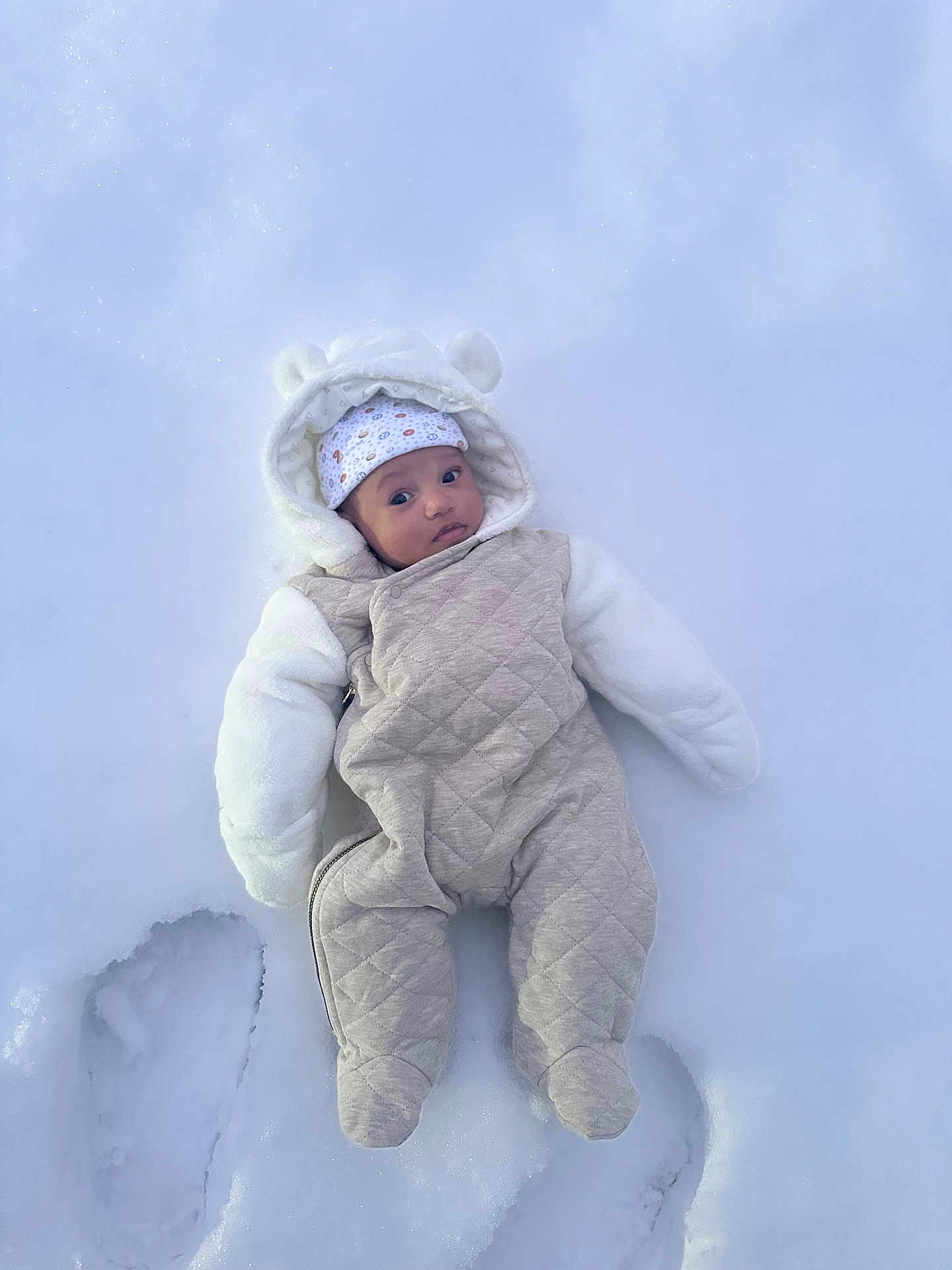 Satori is registered to the contest to win money with this photo: baby, snow, snowsuit, winter_clothing, footprints, outdoor, cold, cute, infant, hood, hat, white, warm, frozen, child, frosty, winter, small, person, playful