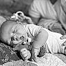 baby, sleeping, toy, hand, quilt, blanket, infant, peaceful, black_and_white, closeup, soft_focus, cuddly, resting, child, cute, portrait, person, indoor, comfort, nap