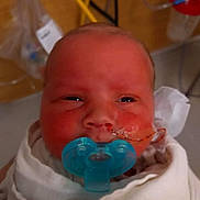 Jason is registered to the contest to win money with this photo: newborn, baby, pacifier, hospital, medical_tube, blanket, face, infant, healthcare, closeup, swaddled, patient, child, indoors, person, head, skin, mouth, feeding_tube, blue