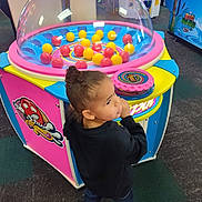 Jasabelle joined the competition — help win amazing prizes! child, arcade, game, balls, colorful, indoor, play, young_child, casual_clothing, black_sweater, jeans, sneakers, entertainment, fun, curly_hair, standing, carpeted_floor, bright_colors, toy, amusement