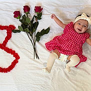 Ayzal joined the competition — help win amazing prizes! baby, child, smiling, red_dress, headband, white_blanket, roses, flower_petals, number_three, celebration, cute, happy, infant, diaper, knee_socks, lying_down, portrait, indoors, joyful, cheerful