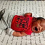 Dakari is registered to the contest to win money with this photo: baby, bed, bedroom, blanket, clothing, cushion, face, furniture, glove, head, homedecor, indoors, newborn, person, photography, portrait, room, sleeping, t_shirt, text