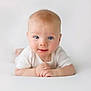 baby, infant, blue_eyes, smile, white_clothing, cute, soft_light, portrait, hands, skin, face, child, lying_down, closeup, innocent, adorable, young, human, expression, background
