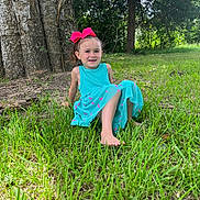 Ava joined the competition — help win amazing prizes! child, girl, smiling, bow, dress, barefoot, grass, tree, outdoor, nature, sunlight, greenery, happy, young, sitting, park, casual, portrait, daytime, leisure
