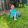 child, girl, smiling, bow, dress, barefoot, grass, tree, outdoor, nature, sunlight, greenery, happy, young, sitting, park, casual, portrait, daytime, leisure