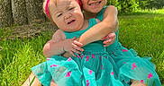 Ava joined the competition — help win amazing prizes! child, children, toddler, grass, tree, outdoor, sunlight, dress, blue_dress, pink_bow, headband, hug, smile, funny_face, nature, summer, cute, sibling, barefoot, happy