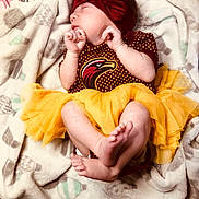 Christina is registered to the contest to win money with this photo: adorable, baby, blanket, bow, child, cozy, cute, face, feet, hands, headband, infant, maroon_outfit, newborn, person, resting, sleeping, soft, tutu, yellow_tutu
