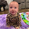 baby, child, cute, eyes, face, happy, indoors, infant, leopard_print, pajamas, photography, play_mat, playroom, portrait, purple_rug, sitting, smiling, storage_bins, toys, wood_floor