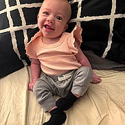 Lyla joined the competition — help win amazing prizes! baby, child, smiling, infant, clothing, sitting, bed, pillow, fabric, cute, happy, person, portrait, indoors, sock, pants, top, face, skin, head