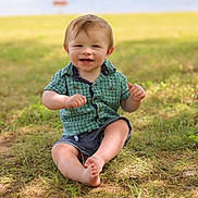Ethan joined the competition — help win amazing prizes! toddler, child, grass, lake, outdoor, smiling, green_shirt, denim_shorts, barefoot, nature, sunlight, happy, portrait, summer, baby, person, sitting, playful, casual_clothing, daytime