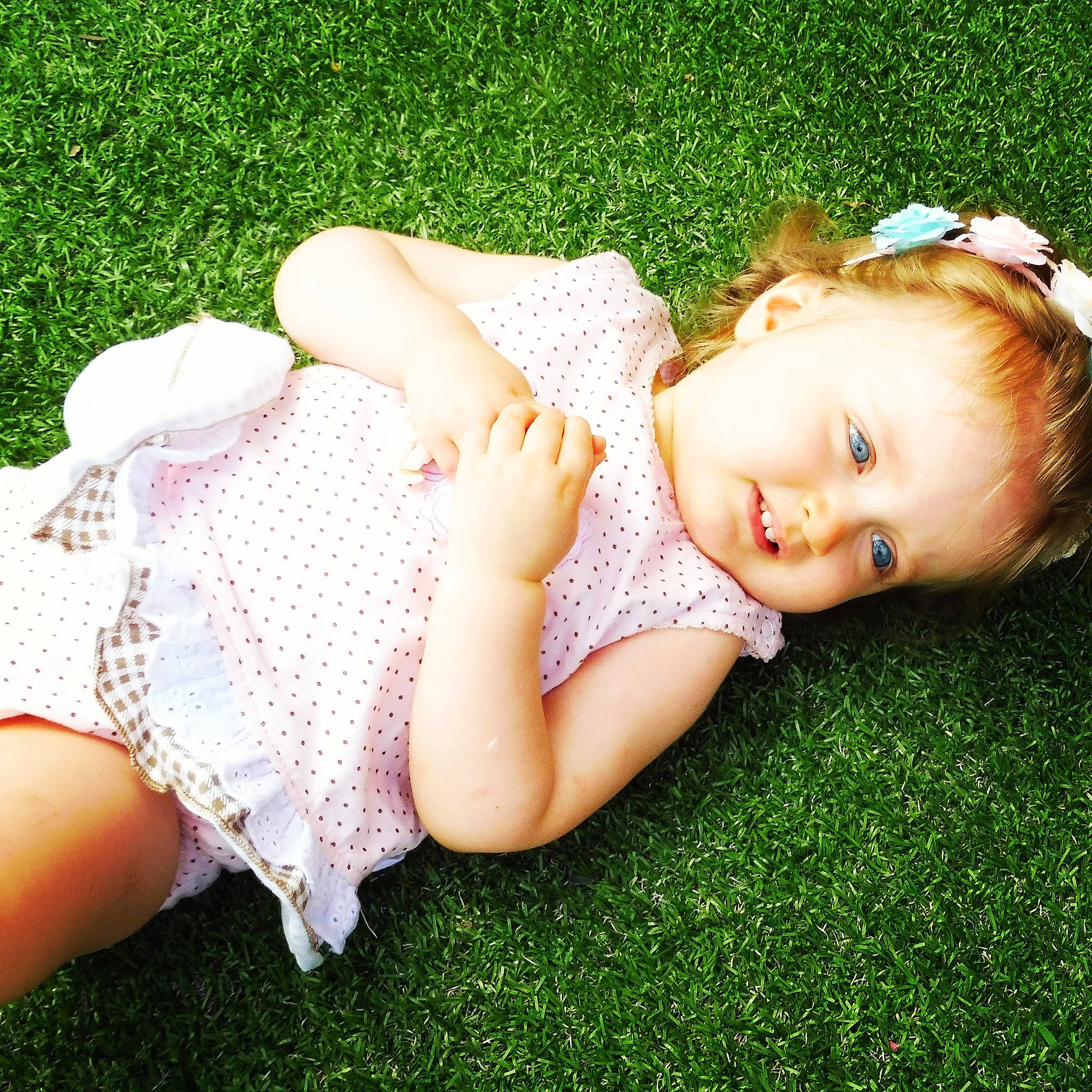 Lizie participe au concours pour gagner de l'argent avec cette photo : baby_toddler_clothing, child, flash_photography, grass, grass_family, grassland, hair_accessory, happy, headband, headgear, headpiece, human_leg, lip, pattern, people_in_nature, person, pink, skin, smile, thigh