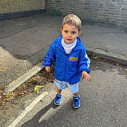 Erdem joined the competition — help win amazing prizes! child, toddler, boy, blue_jacket, sonic_the_hedgehog, shorts, sneakers, street, sidewalk, brick_wall, twig, hairpin, outdoor, daylight, casual_clothing, curious, standing, pavement, shadow, urban