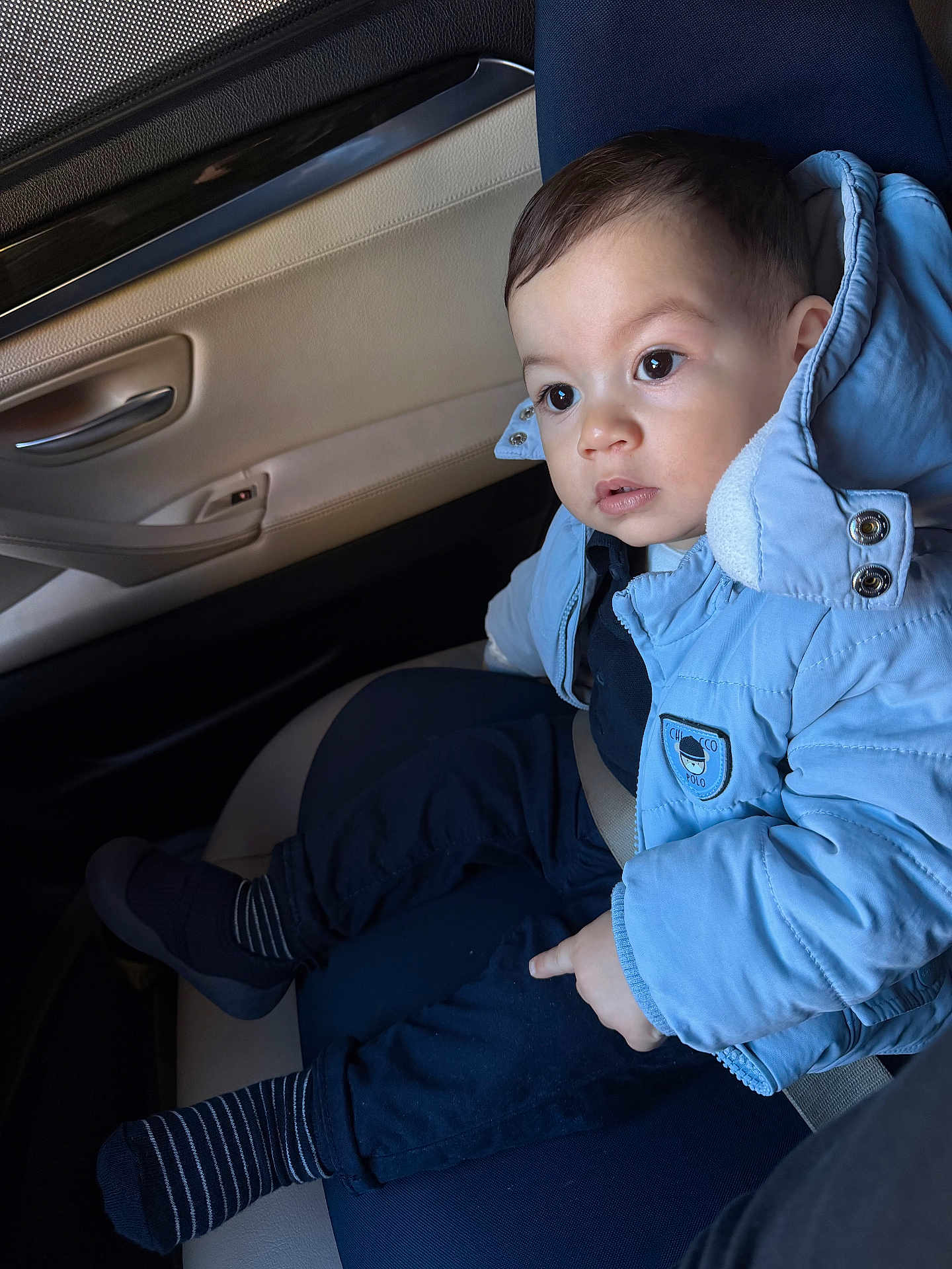 Demir participe au concours pour gagner de l'argent avec cette photo : toddler, child, car_seat, blue_jacket, seatbelt, car_interior, curious_expression, striped_socks, dark_pants, window, door_handle, seat, baby, young_child, warm_clothing, indoors, portrait, person, sitting, casual