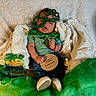 baby, infant, green_clothing, shamrock_glasses, bow_tie, wooden_sign, two_months, blanket, cozy, st_patricks_day, decorations, shamrocks, gold_coins, pacifier, socks, cute, celebration, portrait, holiday, sitting