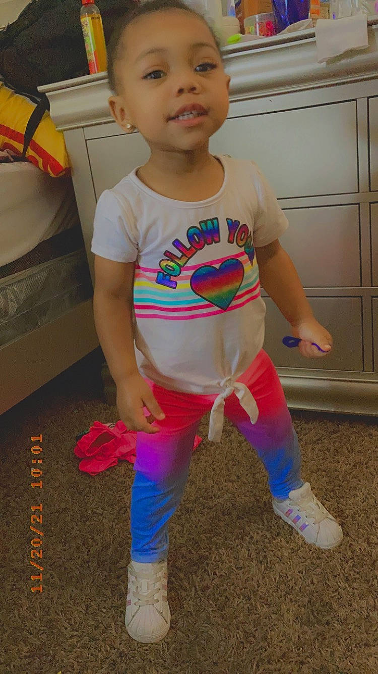 Kahlani is registered to the contest to win money with this photo: abdomen, baby_toddler_clothing, cabinetry, chest, child, face, flooring, fun, happy, human_leg, knee, person, sleeve, sportswear, standing, t_shirt, textile, thigh, toddler, trunk