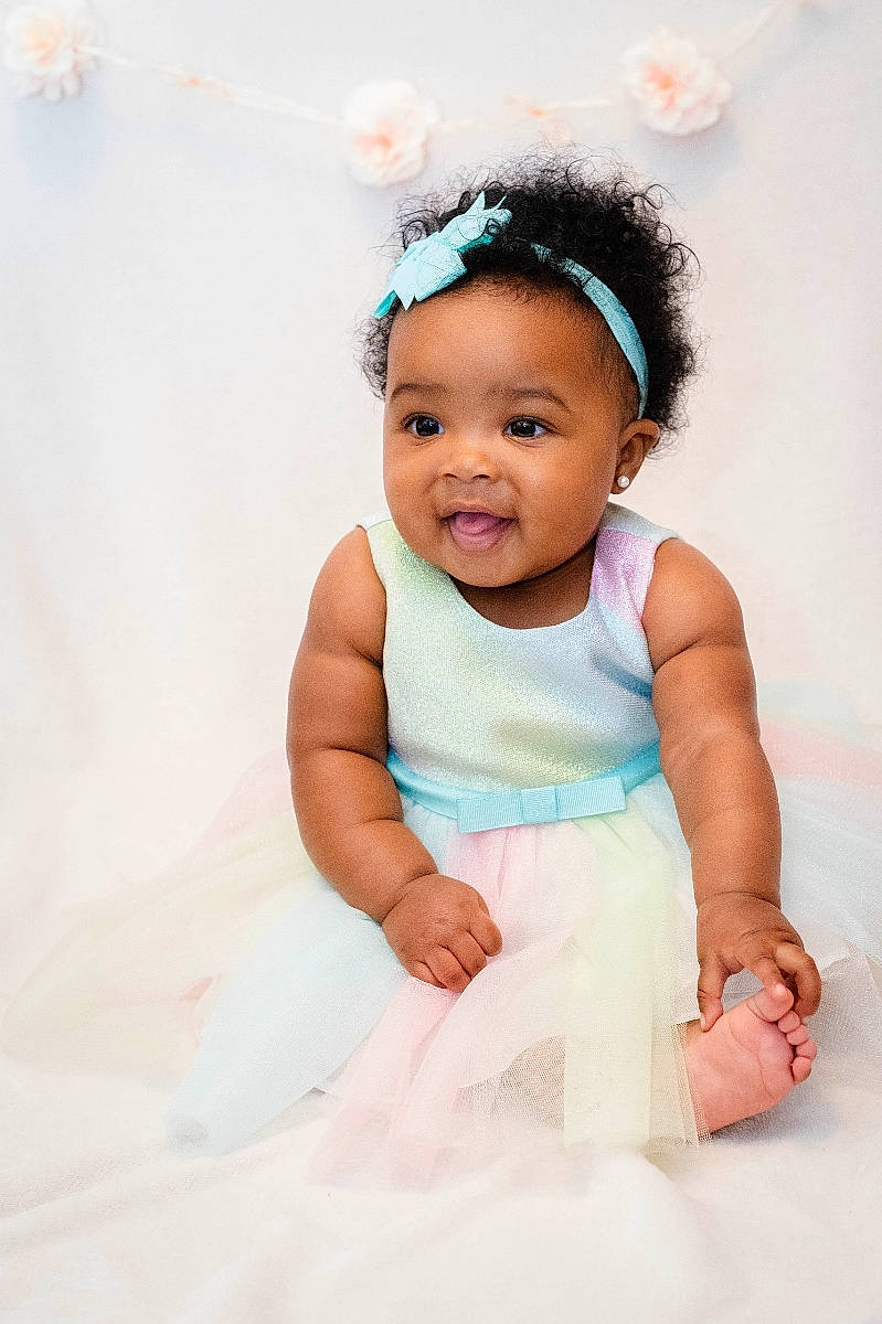 Joy is registered to the contest to win money with this photo: arm, baby, baby_toddler_clothing, child, dress, facial_expression, finger, flash_photography, fun, gesture, happy, headband, headpiece, jewellery, magenta, person, pink, skin, sleeve, smile