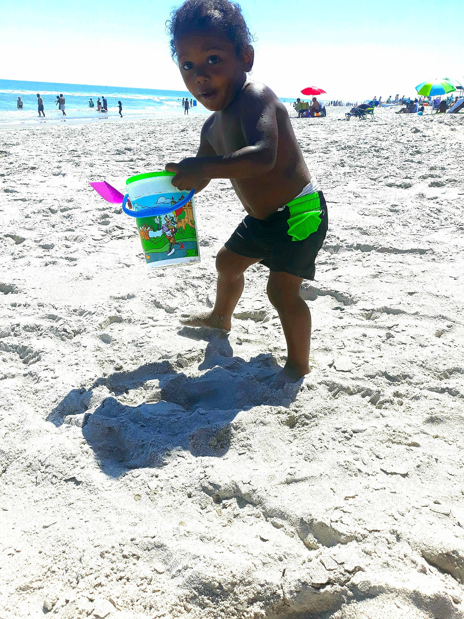 Kareem is registered to the contest to win money with this photo: beach, bucket, child, fun, ocean, person, play, sand, summer, surprise, vacation, water