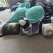 Mochi is registered to the contest to win money with this photo: animal_portrait, calico_cat, cat, costume, couch, cozy, cute, fabric, funny, furniture, green_toy, home, indoor, lying_down, plush_toy, relaxed, sleeping, sofa, stuffed_animal, whiskers