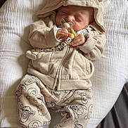 Kayden a rejoint le concours — aidez-le/la à gagner de superbes lots ! baby, infant, sleeping, pacifier, hoodie, beige_clothing, cute, cushion, blanket, toy, white_socks, patterned_pants, child, resting, indoors, soft_lighting, comfort, peaceful, newborn, portrait